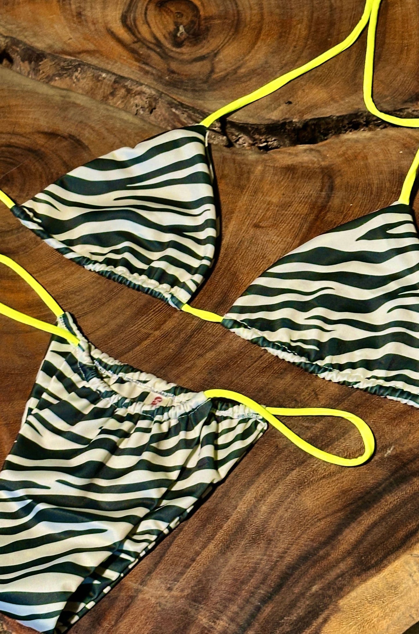 Imagen de producto BIKINI_NEON_SAFARI__CEBRA_TIRAS_NEON, sobre fondo tono madera.